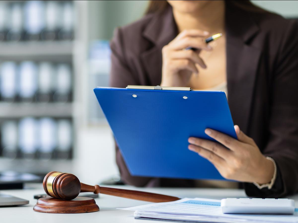 Professional reviewing asset and public-record documents on a clipboard